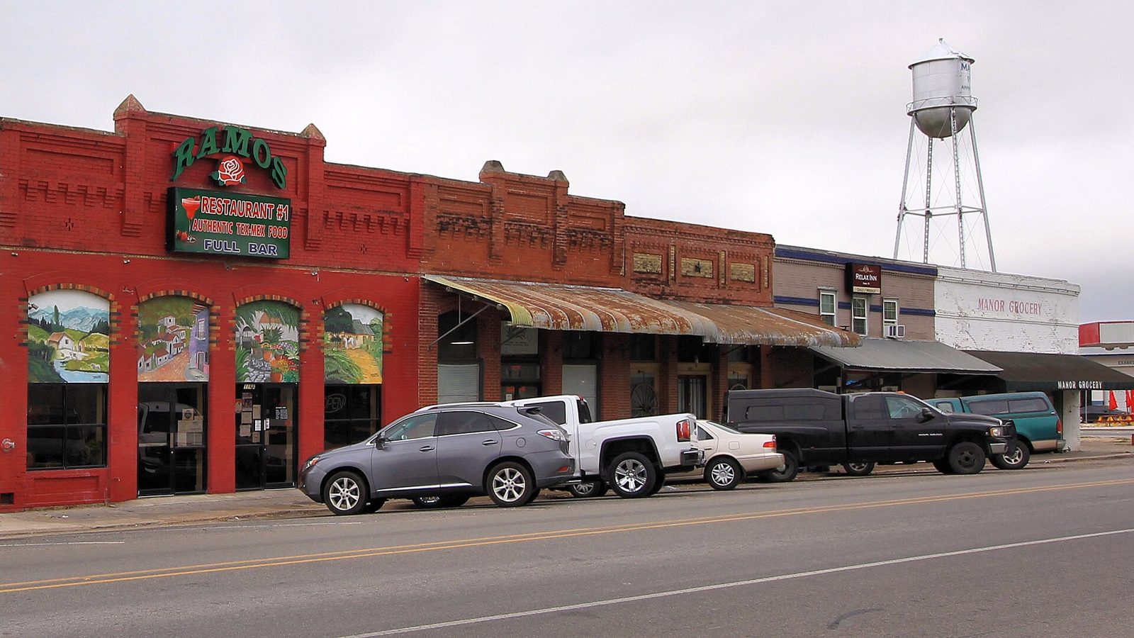 Historic brick storefronts and the water tower in downtown Manor, Texas